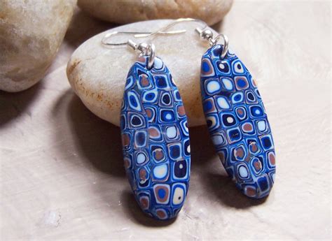 Two Blue Earrings Sitting On Top Of A Rock