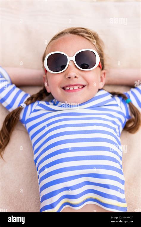 Adorable Little Girl Lying On A Beach Towel During Summer Vacation