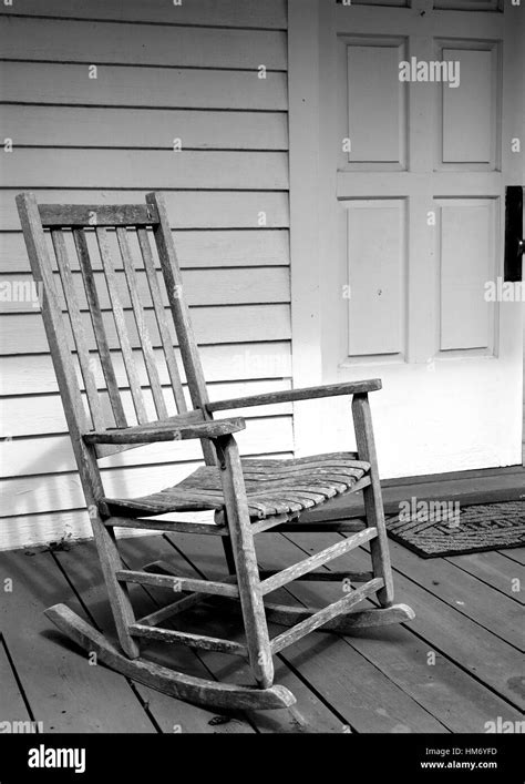 Weathered Vintage Rocking Chair On The Porch Of A White House Stock