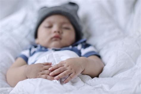 Premium Photo | Safe sleeping for babies Blurry image of adorable baby boy wearing cute hat ...