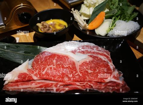 Wooden Table Fulled Of Vegetables Sliced Wagyu Beef And Pork Raw Egg