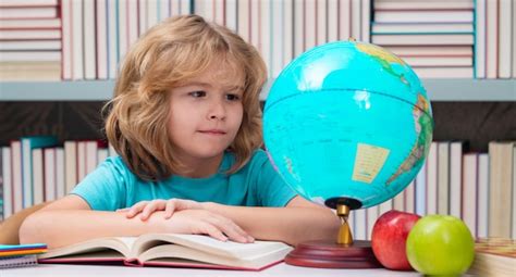 Alumno de la escuela mirando el globo en la biblioteca lección de