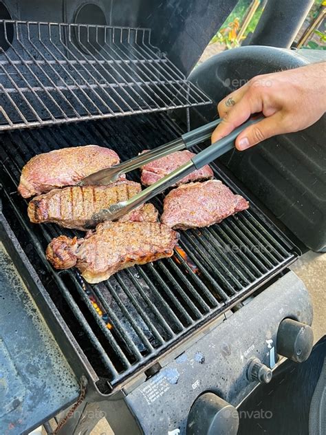 Grilling Seasoned Boneless New York Strip Steak Grilling On A Grill For A Summer Barbecue Stock