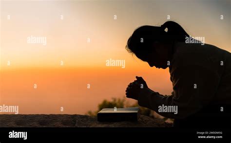 Silhouette Of Woman Kneeling Down Praying For Worship God At Sky