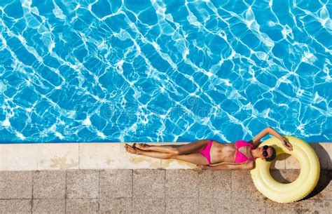 Mujer En El Bikini Que Descansa Sobre El Anillo De Goma Cerca De