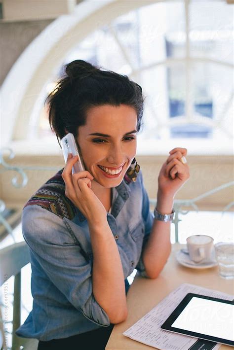 Happy Caucasian Woman Making A Phone Call At A Cafe By Stocksy