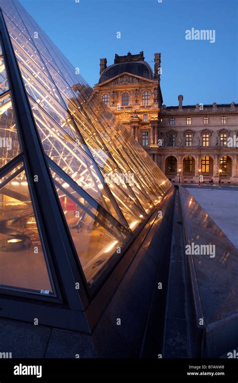 The Louvre Museum with glass pyramid Musée du Louvre at dusk Paris ...