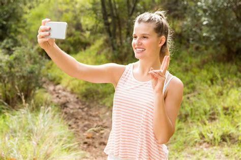 Premium Photo Pretty Blonde Showing Peace Sign And Taking Selfies