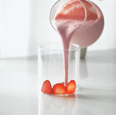 Strawberries Are Being Poured Into A Glass