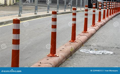 A Barrier Made Of Plastic Columns With Reflective Pigment On An Asphalt