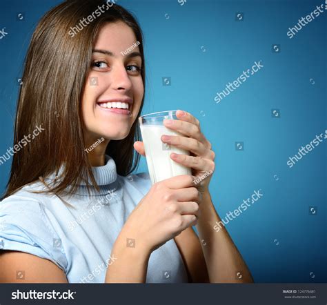 Beautiful Cheerful Teen Girl Drinking Milk Over Blue Background Stock