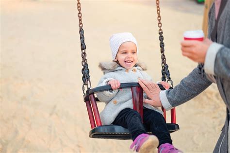 Premium Photo Cheerful Cute Girl Sitting On Swing At Playground