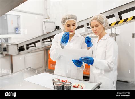 Women Technologists Tasting Ice Cream At Factory Stock Photo Alamy