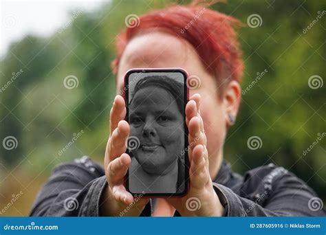 A Woman Holding A Phone In Front Of Her Face Stock Photo Image Of