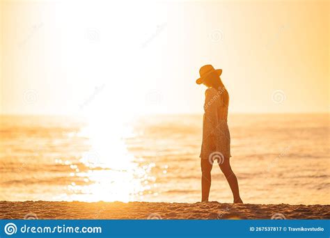 Young Beautiful Woman At Straw Hat On The Beach At Sunset Stock Image