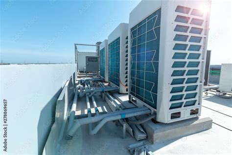 A Row Of Air Conditioning Units On Rooftop With Blue Sky Stock Photo