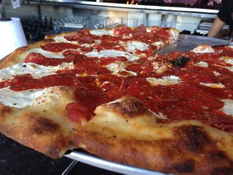 A Large Pizza Sitting On Top Of A Pan Covered In Cheese And Pepperoni