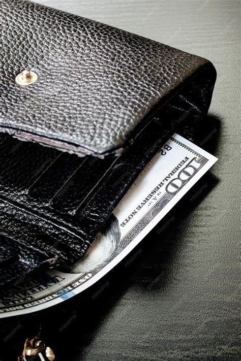 Premium Photo | One hundred dollar bill in black wallet