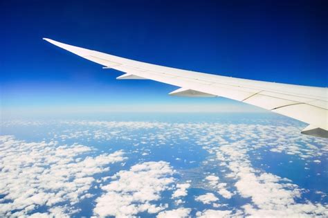 premium photo wing   aircraft flying  blue sky  white