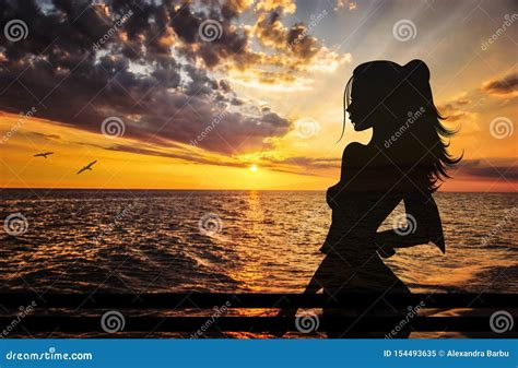 Girl Silhouette Enjoying The Sunset From A Balcony Above The Water