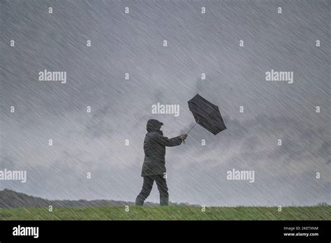 Isolated Woman Standing On A Hillside In Windy Wet And Blustery Uk