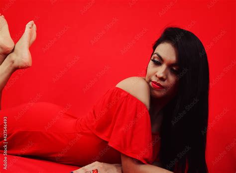 Chica Latina Acostada Con Las Piernas Levantadas Con Vestido Rojo En