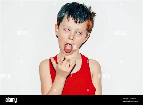 Mischievous Boy With Colorful Dyed Hair Rolling Eyes And Showing Rock