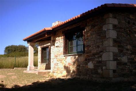 An Old Stone Building With A Red Roof And Window On The Side In Front