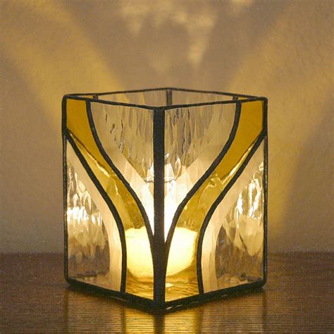 A Glass Candle Holder Sitting On Top Of A Wooden Table