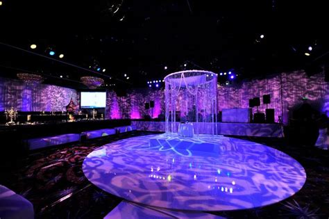 A Stage Set Up For A Party With Purple Lighting And Blue Lights On The