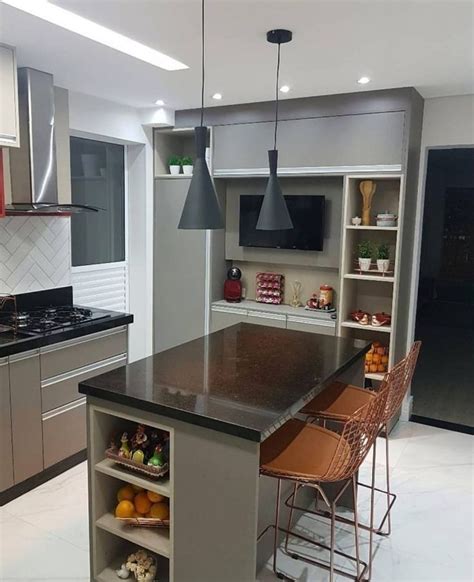 A Kitchen With Stainless Steel Appliances And An Island In The Middle