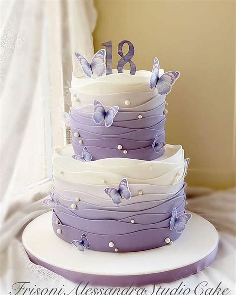 A Three Tiered Cake With Purple Butterflies On It