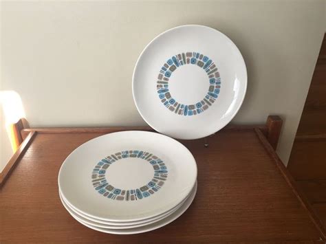 Three White Plates With Blue And Green Designs On Them Sitting On A