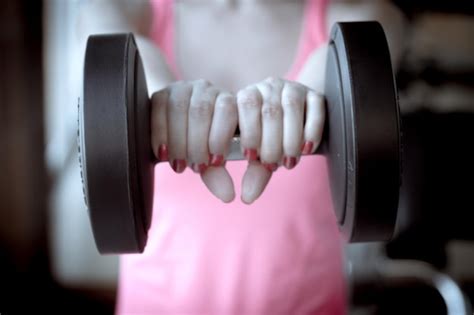 Premium Photo Midsection Of Woman Lifting Dumbbell In Gym