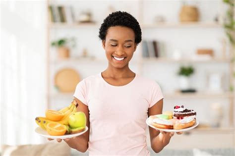 Lovely Black Lady Holding Plates With Fruits And Sweets Looking At