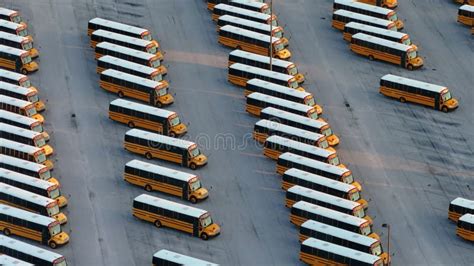 Public School Bus Parking Lot With Many Yellow Buses Parked In Rows