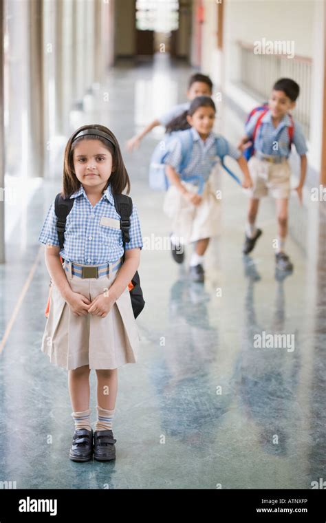 Portrait Of A Schoolgirl Standing In The Corridor With Three Student