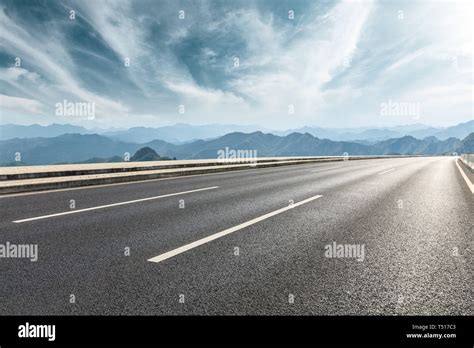 Empty Asphalt Road And Mountains With Beautiful Clouds Landscape Stock