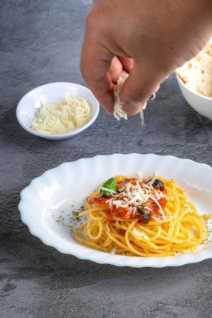 Mano De Hombre Agregando Queso Parmesano En Un Plato De Pasta Italiana