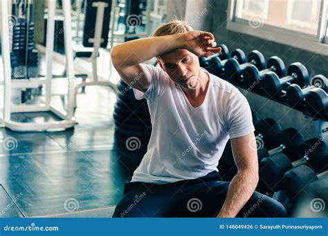 Young Man Wiping Sweat Off Forehead in Gym Stock Photo - Image of muscular, person: 148049426