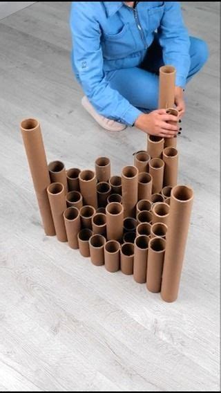 A Woman Kneeling On The Floor Next To A Pile Of Toilet Paper Tubes