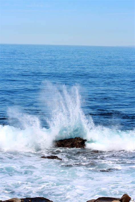 Water Spray From Wave Crashing Into Rocks In The Pacific Ocean Stock