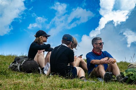 Group of Hikers Resting on a Grassy HilltopFree Stock Photo