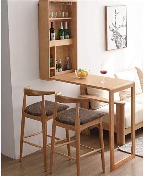 A Table With Two Stools In Front Of It Next To A Wall Mounted Cabinet