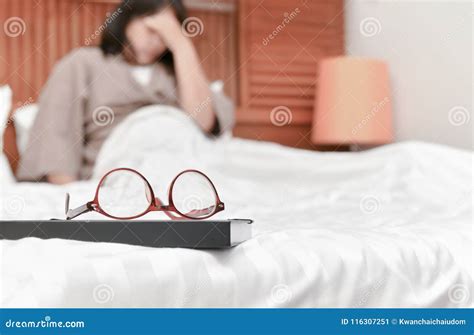 Eyeglasses On Book And Blurred Woman On Bed Background Stock Image Image Of Eyestrain