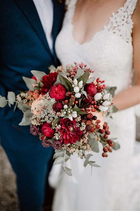 The Bride And Groom Are Holding Their Bouquets