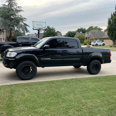 A Black Truck Parked On The Side Of A Road