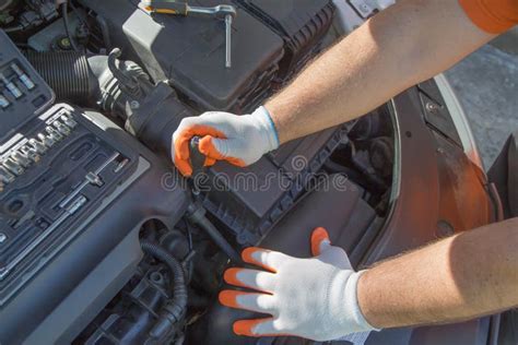 The Mechanic Is Repairing The Car The Mechanic S Hands On The