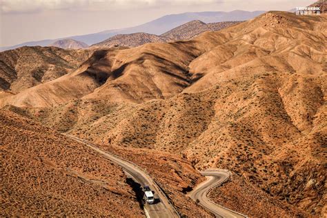 Serpentine roads through dry vegetation in the High Atlas Mountain ...