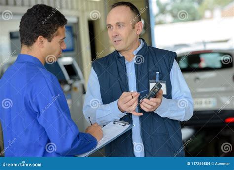 Mechanics Looking at Electronic Device Stock Photo - Image of clipbord